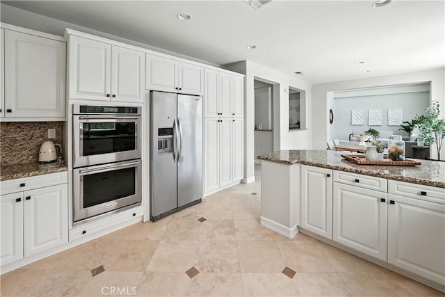 29125 Starwood Pl, Saugus, CA 91390 - kitchen with stainless steel appliances, white cabinetry, dark stone countertops, recessed lighting, and backsplash