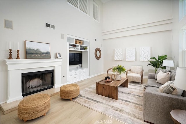 29125 Starwood Pl, Saugus, CA 91390 - living area with wood finished floors, a high ceiling, built in shelves, and a fireplace