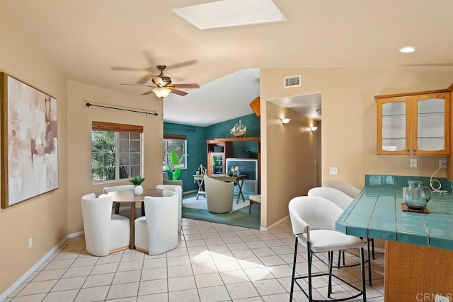 1153 Merritt Dr, El Cajon, CA 92020 - dining space with vaulted ceiling, a skylight, light tile patterned floors, a ceiling fan, and recessed lighting