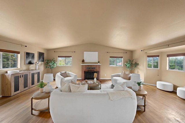 1153 Merritt Dr, El Cajon, CA 92020 - living room featuring wood finished floors, vaulted ceiling, a fireplace, and healthy amount of natural light