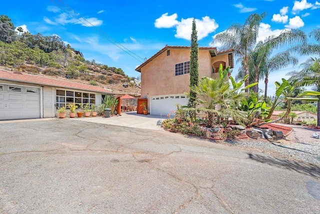 1153 Merritt Dr, El Cajon, CA 92020 - view of side of home featuring stucco siding, driveway, and a garage