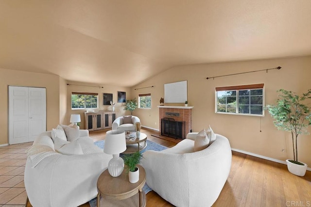 1153 Merritt Dr, El Cajon, CA 92020 - living area featuring vaulted ceiling, a brick fireplace, and light wood-style flooring