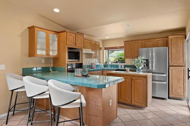 1153 Merritt Dr, El Cajon, CA 92020 - kitchen with stainless steel appliances, a peninsula, under cabinet range hood, glass insert cabinets, and a kitchen bar