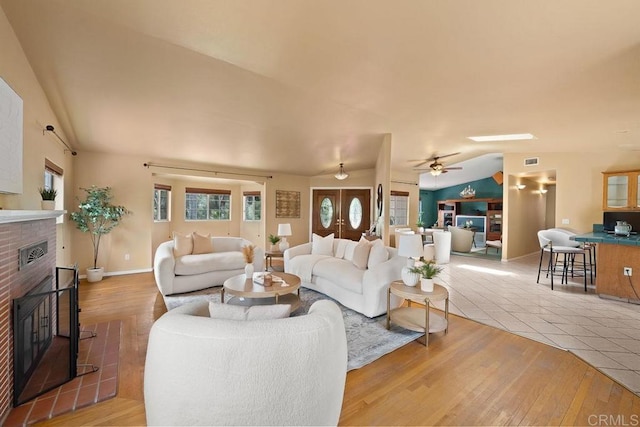 1153 Merritt Dr, El Cajon, CA 92020 - living area featuring light wood-style floors, a brick fireplace, vaulted ceiling, and ceiling fan