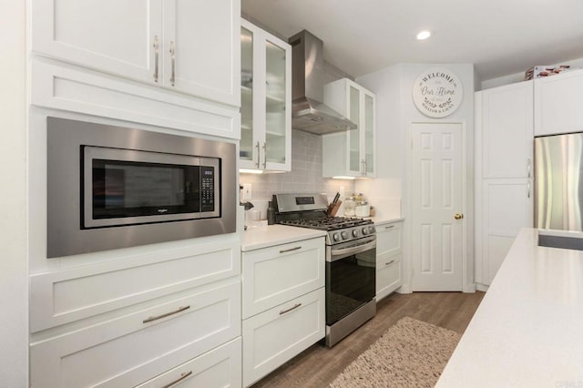 888 Arvita Ct, Oceanside, CA 92057 - kitchen with stainless steel appliances, wall chimney exhaust hood, wood finished floors, light countertops, and white cabinets