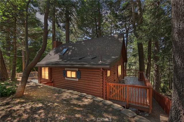 788 Buckingham Sq, Lake Arrowhead, CA 92352 - back of house featuring log exterior, a wooden deck, a chimney, and roof with shingles