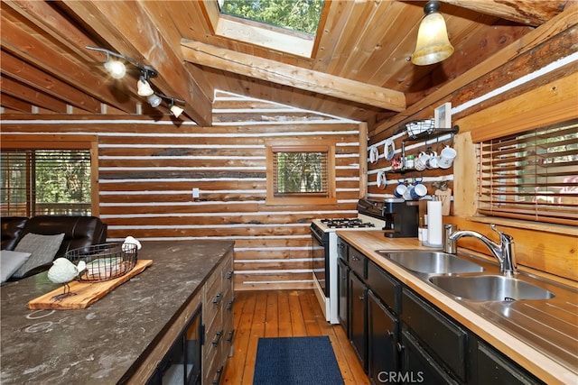 788 Buckingham Sq, Lake Arrowhead, CA 92352 - kitchen with black range with gas stovetop, light wood finished floors, log walls, a skylight, and dark cabinets