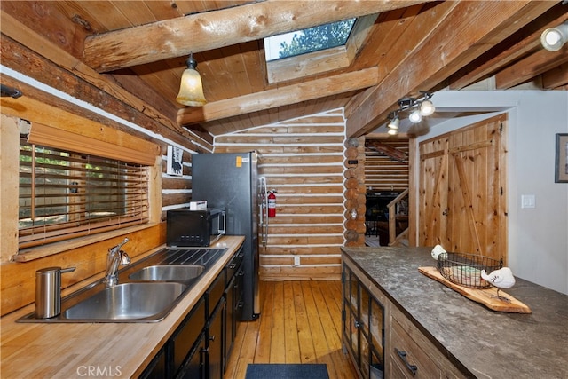 788 Buckingham Sq, Lake Arrowhead, CA 92352 - kitchen with rustic walls, black microwave, wood ceiling, a skylight, and light wood-style floors