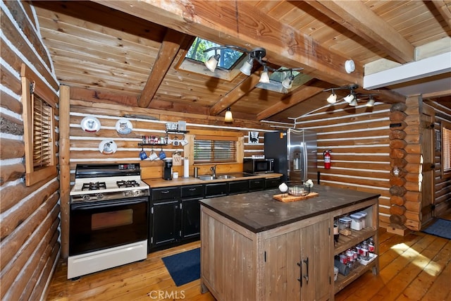 788 Buckingham Sq, Lake Arrowhead, CA 92352 - kitchen with white gas stove, black microwave, log walls, stainless steel fridge, and a wood ceiling with exposed beams