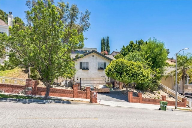 11922 Louise Ave, Granada Hills, CA 91344 - obstructed view of property with an attached garage, driveway, and stucco siding