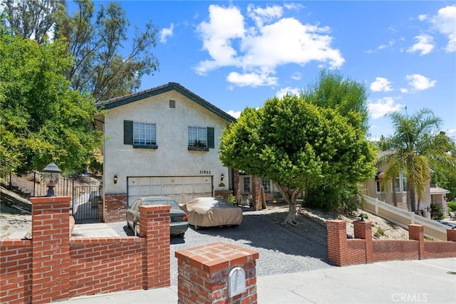 11922 Louise Ave, Granada Hills, CA 91344 - rear view of house featuring a garage, stucco siding, and a gate