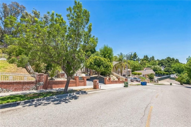 11922 Louise Ave, Granada Hills, CA 91344 - view of asphalt street featuring sidewalks, street lighting, and curbs