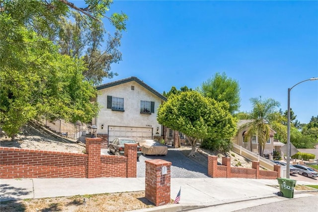 11922 Louise Ave, Granada Hills, CA 91344 - view of front of house featuring a garage, stucco siding, and driveway