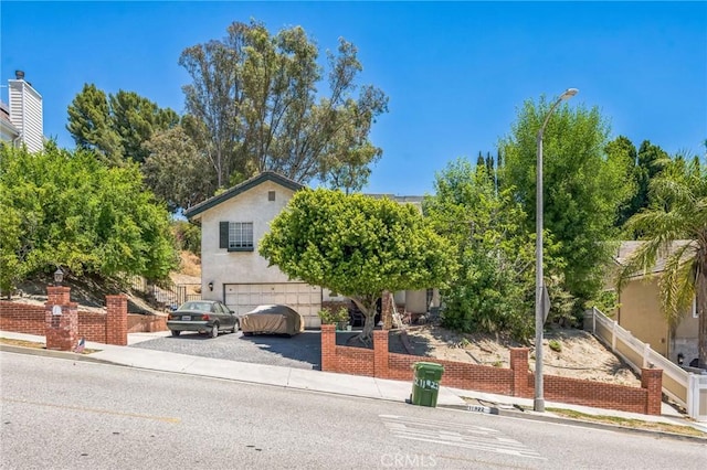 11922 Louise Ave, Granada Hills, CA 91344 - view of property hidden behind natural elements featuring an attached garage and driveway