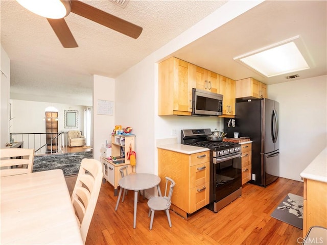 9228 Elm Vista Dr Unit B, Downey, CA 90242 - kitchen with appliances with stainless steel finishes, light wood-style floors, light brown cabinetry, a ceiling fan, and light countertops