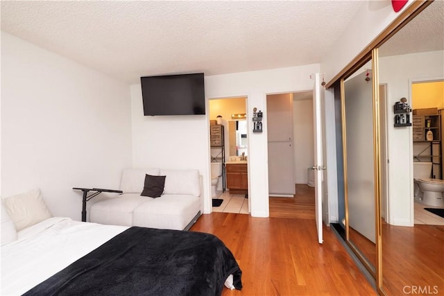 9228 Elm Vista Dr Unit B, Downey, CA 90242 - bedroom featuring wood finished floors, connected bathroom, a textured ceiling, and a closet