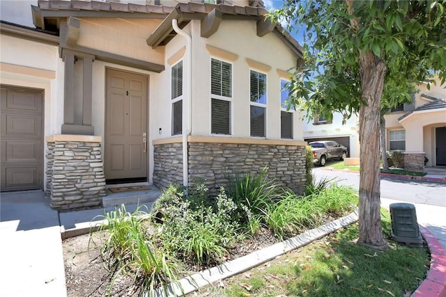 434 Sonora Cir, Redlands, CA 92373 - doorway to property with stone siding, stucco siding, and a garage