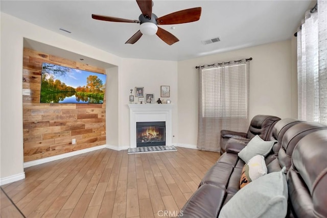 434 Sonora Cir, Redlands, CA 92373 - living area featuring ceiling fan, wood finished floors, a glass covered fireplace, and wood walls