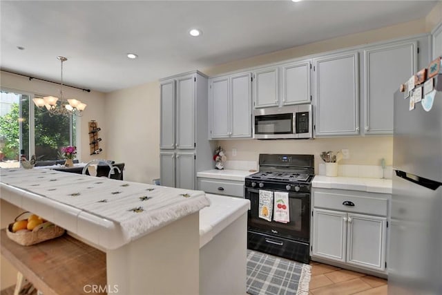 434 Sonora Cir, Redlands, CA 92373 - kitchen with stainless steel appliances, a chandelier, tile countertops, recessed lighting, and decorative light fixtures