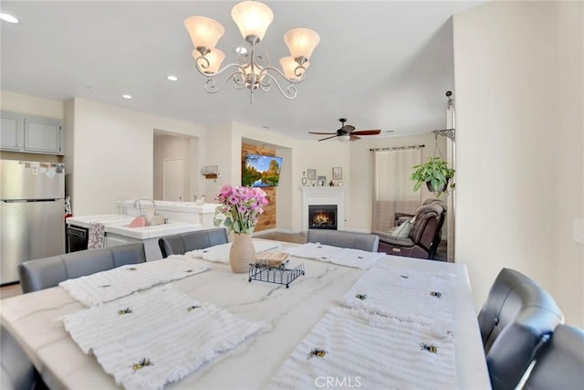 434 Sonora Cir, Redlands, CA 92373 - dining area with a chandelier, a warm lit fireplace, a ceiling fan, and recessed lighting