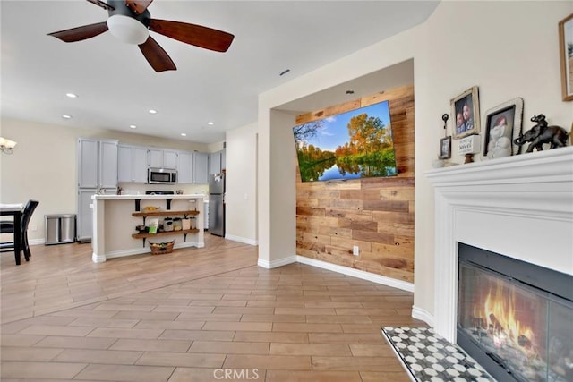 434 Sonora Cir, Redlands, CA 92373 - living area with a glass covered fireplace, ceiling fan, recessed lighting, and wood walls
