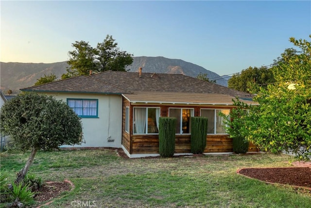 8220 Owens St, Sunland, CA 91040 - back of house at dusk featuring a lawn and a mountain view