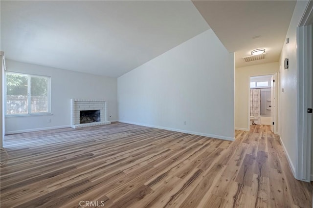 2950 Marie Ln, Merced, CA 95340 - unfurnished living room with wood finished floors, healthy amount of natural light, a brick fireplace, and lofted ceiling
