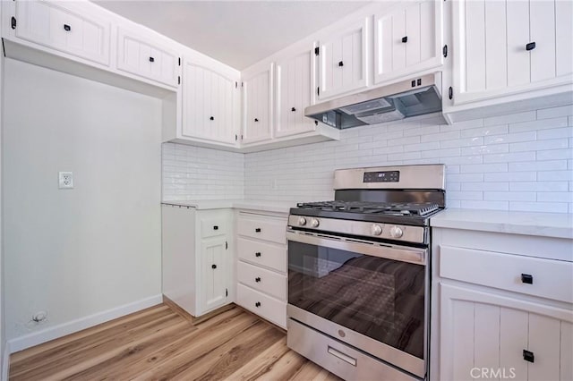 2950 Marie Ln, Merced, CA 95340 - kitchen featuring stainless steel gas stove, under cabinet range hood, light countertops, light wood-style flooring, and white cabinetry