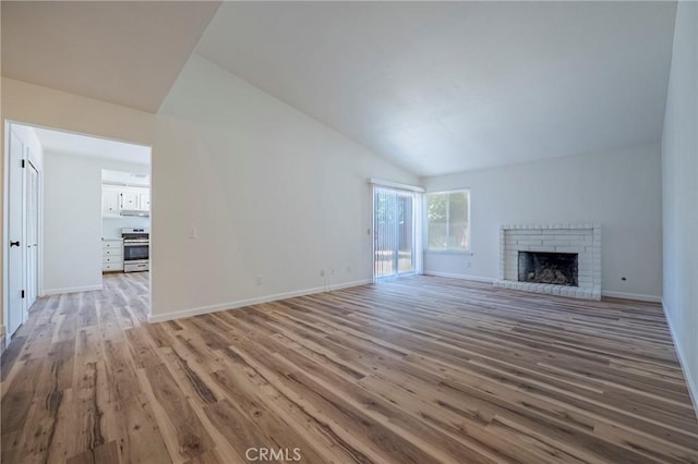 2950 Marie Ln, Merced, CA 95340 - unfurnished living room with lofted ceiling, light wood-style flooring, and a fireplace