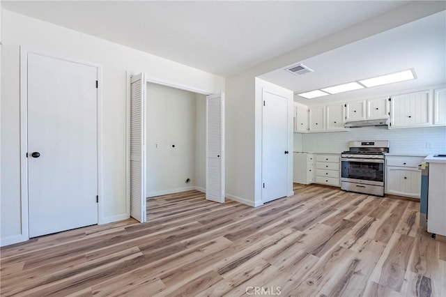 2950 Marie Ln, Merced, CA 95340 - kitchen featuring gas stove, under cabinet range hood, light wood-style flooring, light countertops, and white cabinets