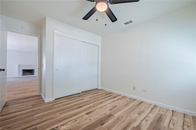 2950 Marie Ln, Merced, CA 95340 - unfurnished bedroom featuring light wood finished floors, a fireplace, and a closet