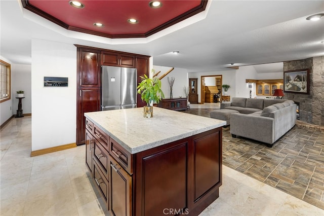 981 Deep Springs Dr, Claremont, CA 91711 - kitchen featuring freestanding refrigerator, reddish brown cabinets, recessed lighting, a center island, and light stone countertops