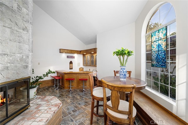 981 Deep Springs Dr, Claremont, CA 91711 - dining room featuring stone finish floors, wet bar, lofted ceiling, plenty of natural light, and a multi sided fireplace