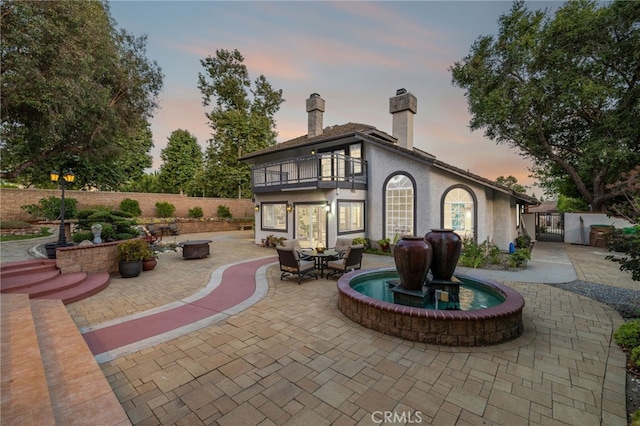 981 Deep Springs Dr, Claremont, CA 91711 - back of house featuring a balcony, a patio area, a chimney, a gate, and stucco siding