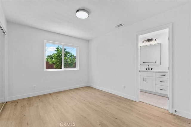 25415 Paloma Rd, San Bernardino, CA 92410 - unfurnished bedroom featuring light wood finished floors and connected bathroom