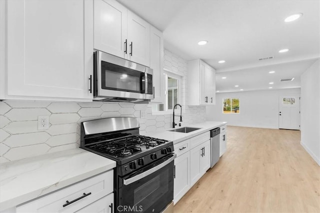 25415 Paloma Rd, San Bernardino, CA 92410 - kitchen with stainless steel appliances, recessed lighting, tasteful backsplash, light wood finished floors, and white cabinetry