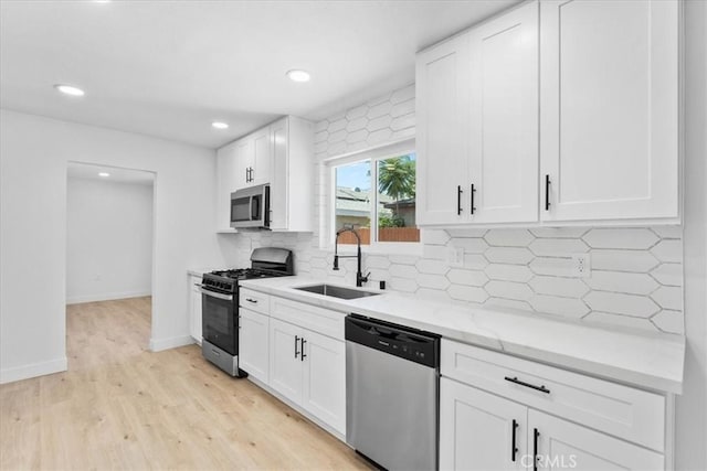 25415 Paloma Rd, San Bernardino, CA 92410 - kitchen with appliances with stainless steel finishes, light wood-type flooring, white cabinets, tasteful backsplash, and recessed lighting