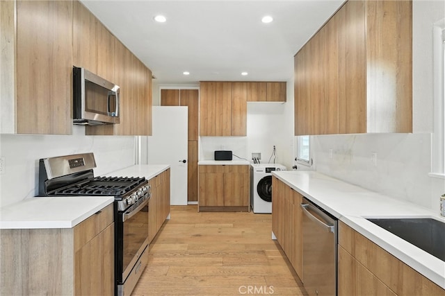 4752 Josie Ave, Lakewood, CA 90713 - kitchen featuring appliances with stainless steel finishes, modern cabinets, light wood-style floors, recessed lighting, and washer / dryer