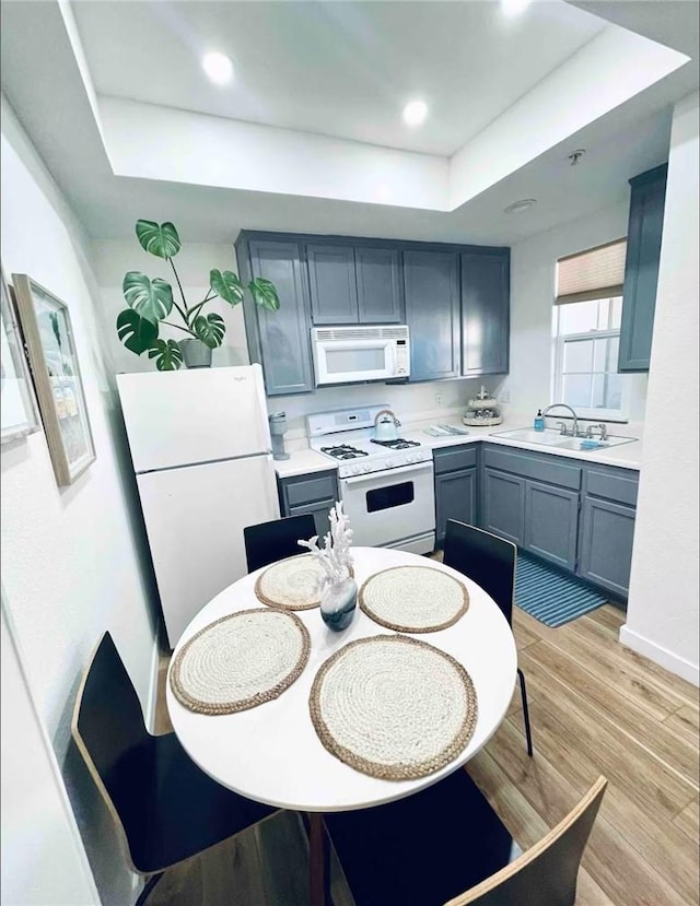 444 Pier Ave Unit 4, Oceano, CA 93445 - kitchen with white appliances, a tray ceiling, light countertops, light wood-style floors, and recessed lighting