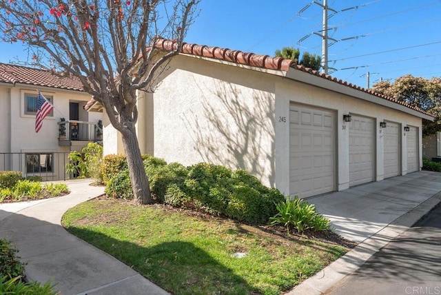 245 Fairlee Ln, Encinitas, CA 92024 - view of property exterior with stucco siding, community garages, and a tiled roof