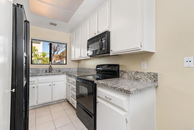 245 Fairlee Ln, Encinitas, CA 92024 - kitchen with black appliances, light tile patterned floors, white cabinets, and light stone countertops