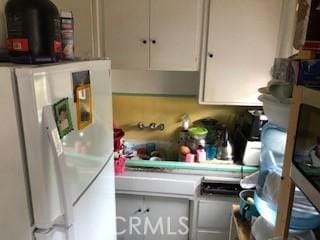 9611 Mallison Ave, South Gate, CA 90280 - kitchen featuring freestanding refrigerator and white cabinetry