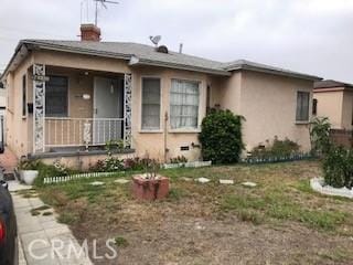 9611 Mallison Ave, South Gate, CA 90280 - view of front of property featuring stucco siding, covered porch, and a chimney