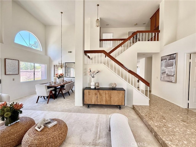 18 Decente, Irvine, CA 92614 - carpeted living area with a high ceiling, stairs, and a chandelier