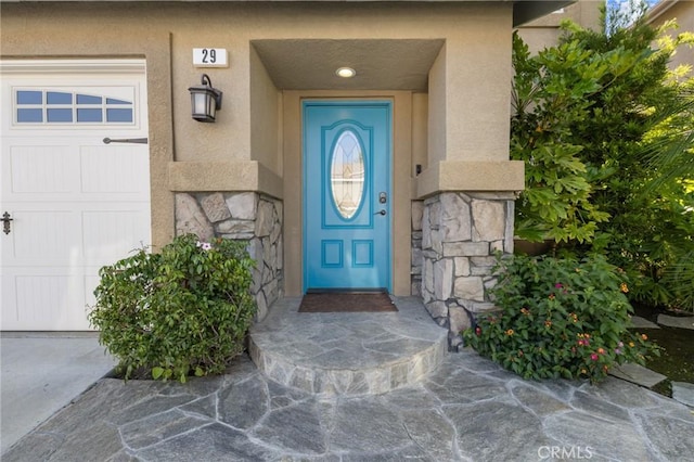 29 Hemingway Ct, Trabuco Canyon, CA 92679 - property entrance with stucco siding, stone siding, and a garage