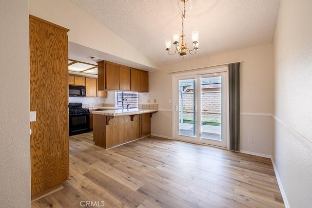 43920 Delgado Ct, Lancaster, CA 93535 - kitchen with black appliances, a chandelier, light wood-type flooring, a peninsula, and light countertops