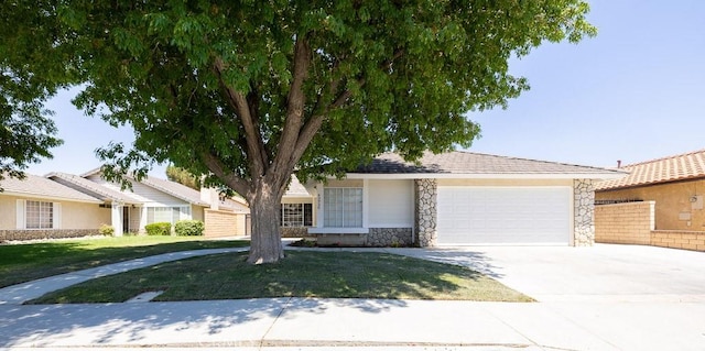 43920 Delgado Ct, Lancaster, CA 93535 - view of front of home featuring stone siding, concrete driveway, a garage, and a front yard