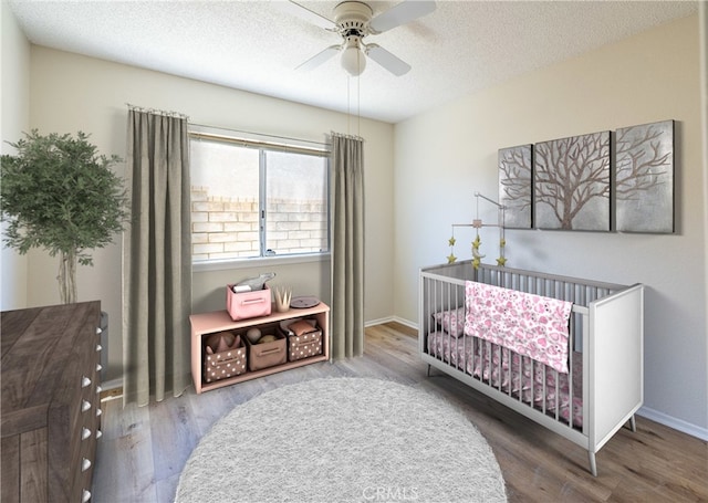 43920 Delgado Ct, Lancaster, CA 93535 - bedroom with a nursery area, wood finished floors, a textured ceiling, and a ceiling fan
