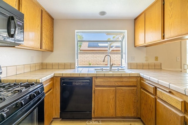 43920 Delgado Ct, Lancaster, CA 93535 - kitchen featuring black appliances, brown cabinets, and light countertops
