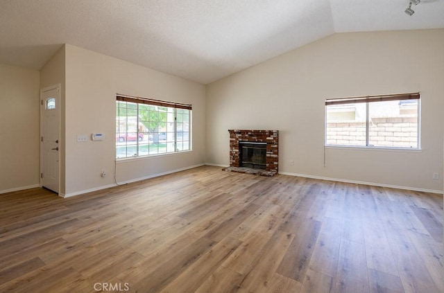 43920 Delgado Ct, Lancaster, CA 93535 - unfurnished living room with lofted ceiling, wood finished floors, and a fireplace